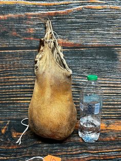 an old bag and water bottle sitting on a wooden table next to a tag that says,