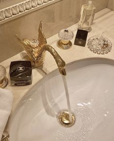 a bathroom sink with gold faucet and soap dispenser