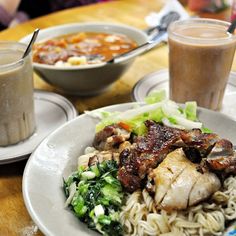 the meal is ready to be eaten on the table with two cups of coffee in the background