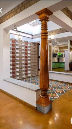 the inside of a house with wooden pillars and tile flooring on either side of it