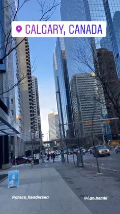 there is a sign that says calgary, canada in front of tall buildings on the street