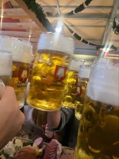 a group of people sitting at a table with beer glasses on top of their heads