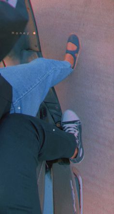 a person wearing blue jeans and black shoes standing on a ramp with their feet in the air