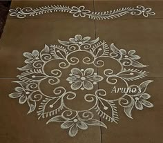 an intricately designed sidewalk with white paint on the ground and flowers painted on it