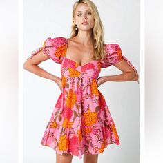 Slip Into The Jessie Pink Floral Babydoll Mini Dress For A Delightful Brunch With Friends! This Dress Features A Charming Blend Of Pink, Yellow, And Orange In Its Floral Design, Crafted From Woven Fabric For A Light And Airy Feel. Its Sweetheart Neckline And Empire Waist Bodice Are Complemented By Puffy Short Sleeves, Complete With Ties And Elasticized Shoulders For A Snug Fit. The Babydoll Style Cascades Into A Playful Mini Skirt, Finished With A Ruffle Hem For A Touch Of Whimsy. Fully Lined Fo Babydoll Mini Dress, Floral Babydoll Dress, Tiered Ruffle Skirt, Babydoll Style, Pink Floral Dress, Pink Boho, Puffed Sleeves Dress, Sweet Dress, Babydoll Dress