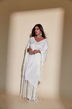 SOL FRINGE KAFTAN - OFF WHITE – Kadimah Vacation V-neck Kaftan With Tassel Ties, Elegant White V-neck Kaftan, Chic White Flowy Kaftan, Elegant Long Sleeve Kaftan With Tassels, Spring Kaftan With Tassels And Kimono Sleeves, Spring Maxi Kaftan With Tassels, Chic White Kaftan For Beach Cover-up, White Fringe V-neck Dress, White V-neck Dress With Fringe