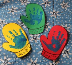 three handprinted gloves sitting on top of a blue and white cloth covered table