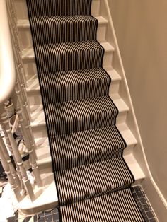 the stairs are lined with black and white striped carpet