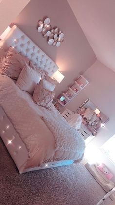 a bedroom with a large bed and lots of lights on the headboard is shown