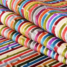 multicolored rugs stacked on top of each other