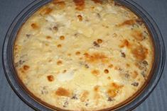 a casserole dish with cheese and meat in it on a blue table cloth