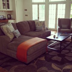 a living room with two couches, a coffee table and windows in the background