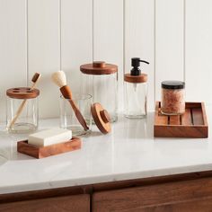 a counter with soap, brush, and other items on it that says west elm