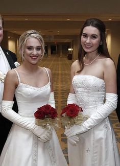 three people dressed in formal wear standing next to each other