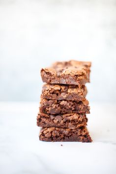 a stack of brownies sitting on top of a white counter next to each other