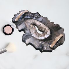 an eye shadow and brush on a marble tray