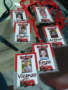 four red and white tags with pictures of children's faces hanging from the side of a car