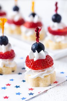 small desserts with strawberries and blueberries on them are arranged in patriotic colors