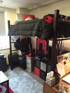 a room with bunk beds, desks and other items on the floor in it