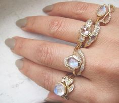 a close up of a person's hand with three rings on their fingers and one is wearing a diamond ring