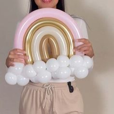 a woman is holding balloons in front of her face