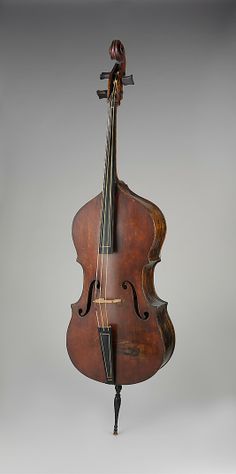 an old violin hanging from the back of it's neck on a gray background