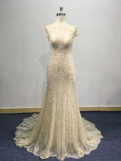 a dress on display in a room with blue carpet and white wall behind the mannequin