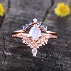 a ring with an opal and blue topazte surrounded by diamonds on a piece of wood