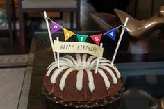 a chocolate cake with white icing and bunting flags on it's top