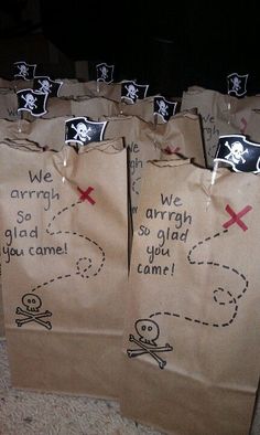 several brown paper bags with writing on them and pirate symbols drawn on the side of each bag