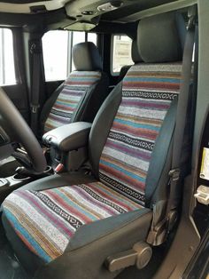 the interior of a vehicle with multi colored seat covers and dash stripes on the seats