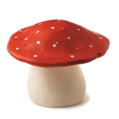 a red mushroom sitting on top of a white base