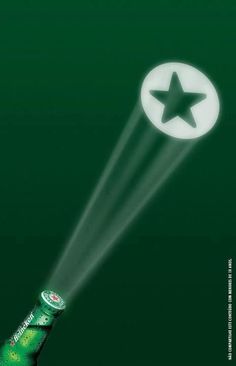 an advertisement for heineken beer with a star on the bottle and light coming from it