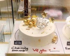 a white cake with gold decorations in a display case