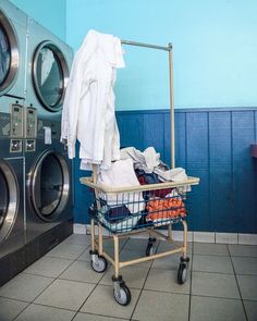 a laundry basket filled with clothes next to a washer and dryer