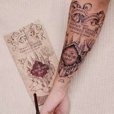 a person with a harry potter tattoo on their arm next to an old book and scissors