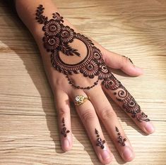 a woman's hand with henna tattoos on it