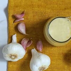 garlic and butter on a yellow towel next to some cloves