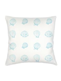 a blue and white pillow with seashells printed on it's front side