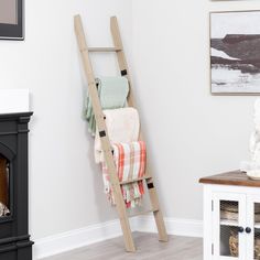 a ladder leaning up against the wall with towels on it next to a fire place