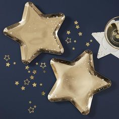 two star shaped plates sitting next to each other on a blue surface with gold stars