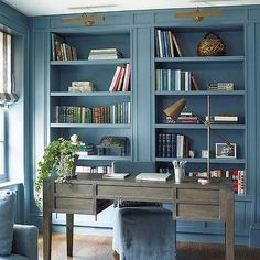 a home office with blue walls and built - in bookshelves