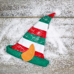 a colorful christmas hat sitting on top of snow covered ground