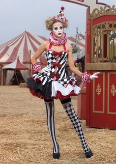 a woman dressed as a clown standing in front of a carnival tent with her hands on her hips