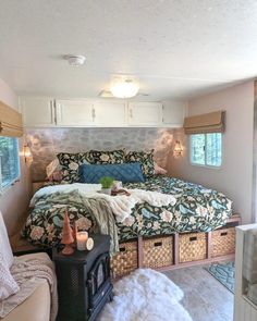 a small bedroom with a bed, couch and storage boxes in it's corner