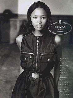 a black and white photo of a woman with a prada sign in her hand