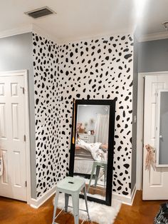 the room is decorated with black and white wallpaper, including a cheetah pattern