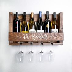 wine glasses and bottles are lined up on a shelf