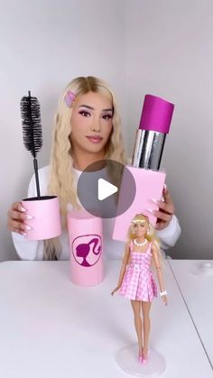 a barbie doll holding up two cups and a brush