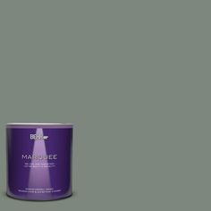 a can of behr marquee paint on a green background